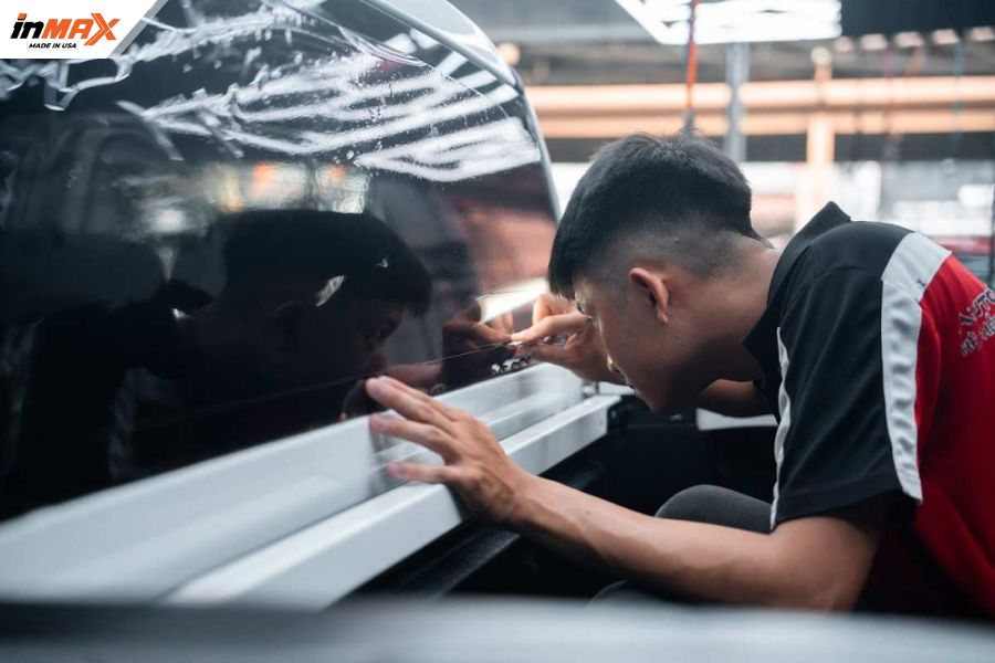 Hình ảnh kỹ thuật viên Inmax đang thực hiện dán phim phản xạ nhiệt ô tô